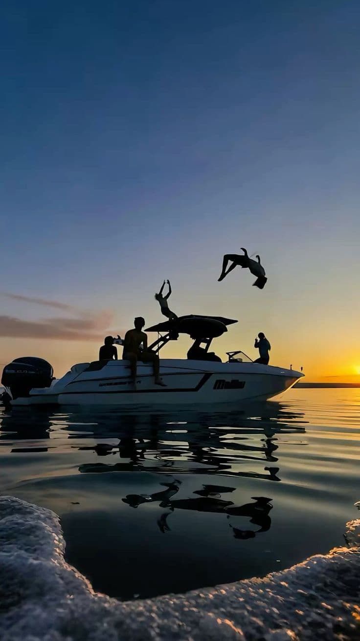 Grupo saltando desde una barca al atardecer en un viaje de fin de curso